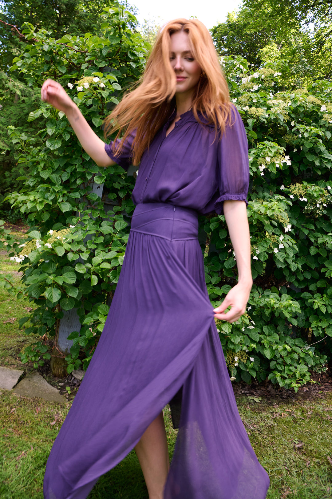 Model moving through a garden in flowing plum ba&sh separates